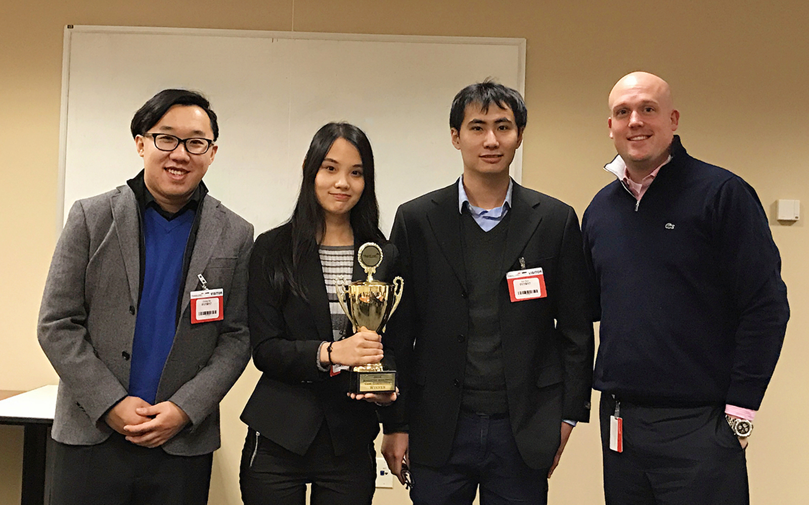 Photo, left to right: MSBAPM students Zhong He '17, Xin "Amy" Ni '16, and Jun Sun '16 pose for a photo with Patrick Buckley, manager of the Advanced Analytics Leadership Development Program at Travelers, following the UConn team’s victory. (Xin "Amy'' Ni)