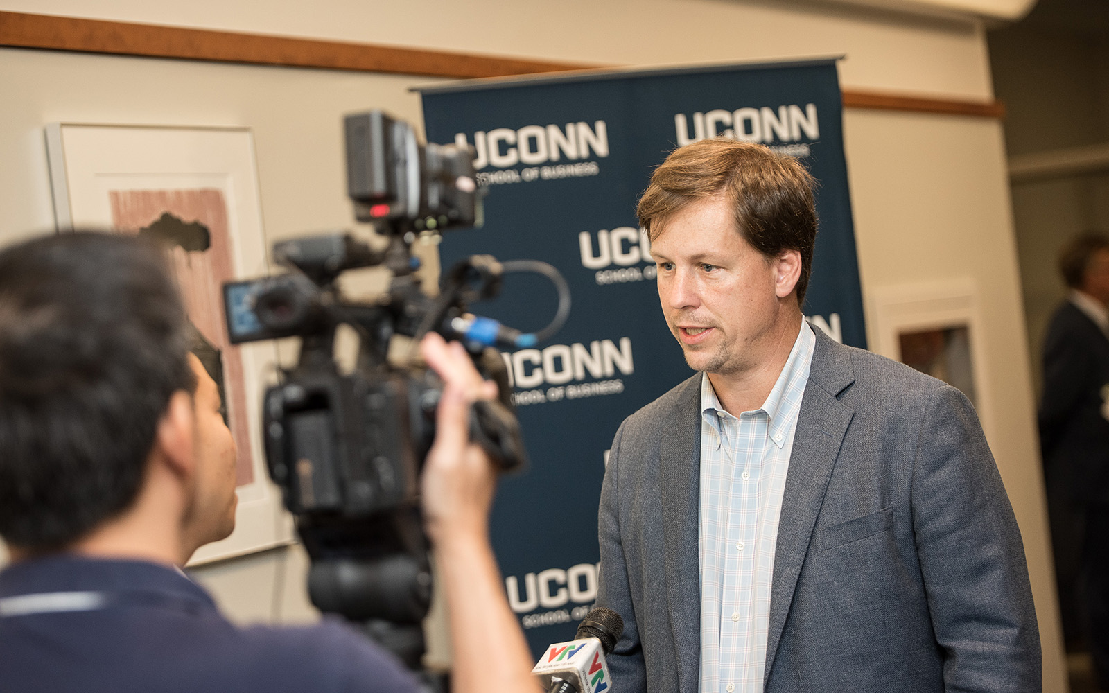 Professor David Noble, co-chair of the UConn Blockchain symposium, is interviewed by a reporter from Vietnam’s state news agency. (Nathan Oldham/UConn School of Business)