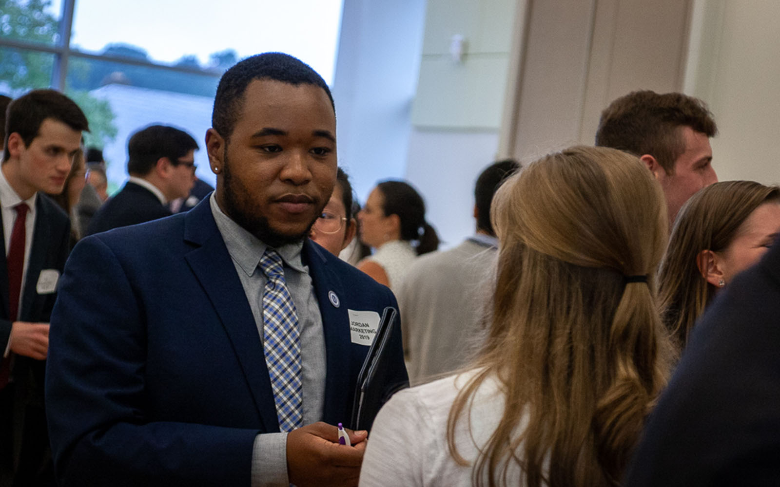 During the 2018 Career Expo, Jordan Hatten (Marketing) has a conversation with one of the visiting businesspoeple. (Devin Basdekian/UConn School of Business)