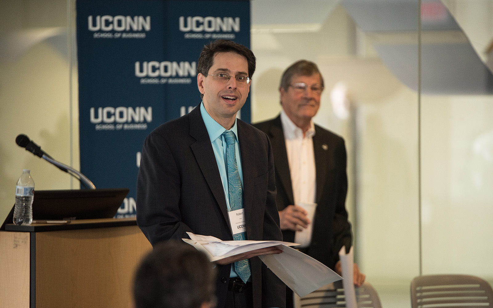 Professor Robert Bird (left) speaks during the Summit on the Academic Profession of Business Law, with Interim Provost John Elliott (Right) behind him. (Nathan Oldham / UConn School of Business) 