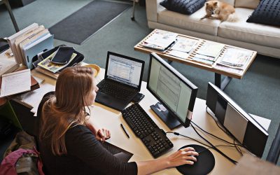 Woman seated at a computer in a home office. 