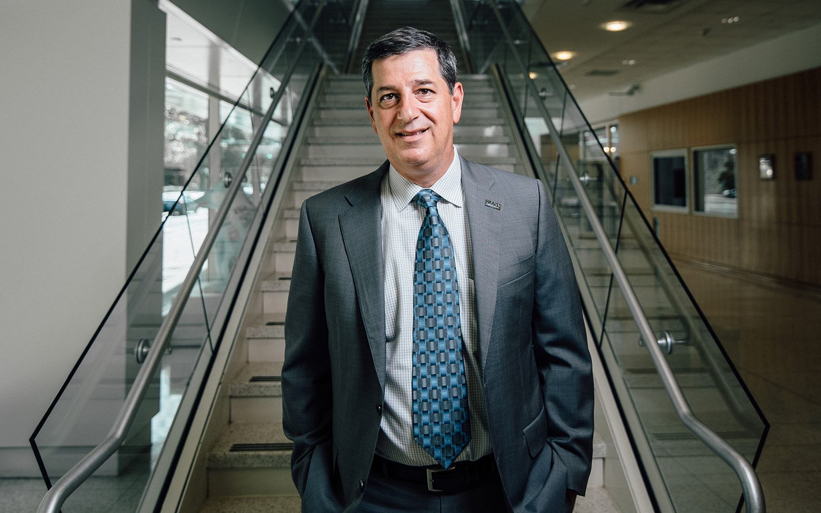 Former Walmart CEO Bill Simon poses in front of an escalator in the UConn Stamford campus. 