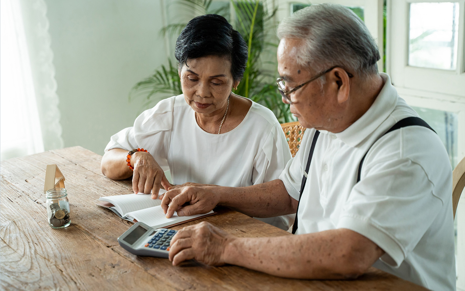 Asian senior couple stressed and serious counting with calculator and having money problem