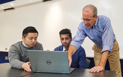 Blake Mather, an adjunct faculty member, meets with student managed fund members Di Yang, left, and Anshul Manglani, both graduate students, at the Stamford campus. (Peter Morenus/UConn Photo)