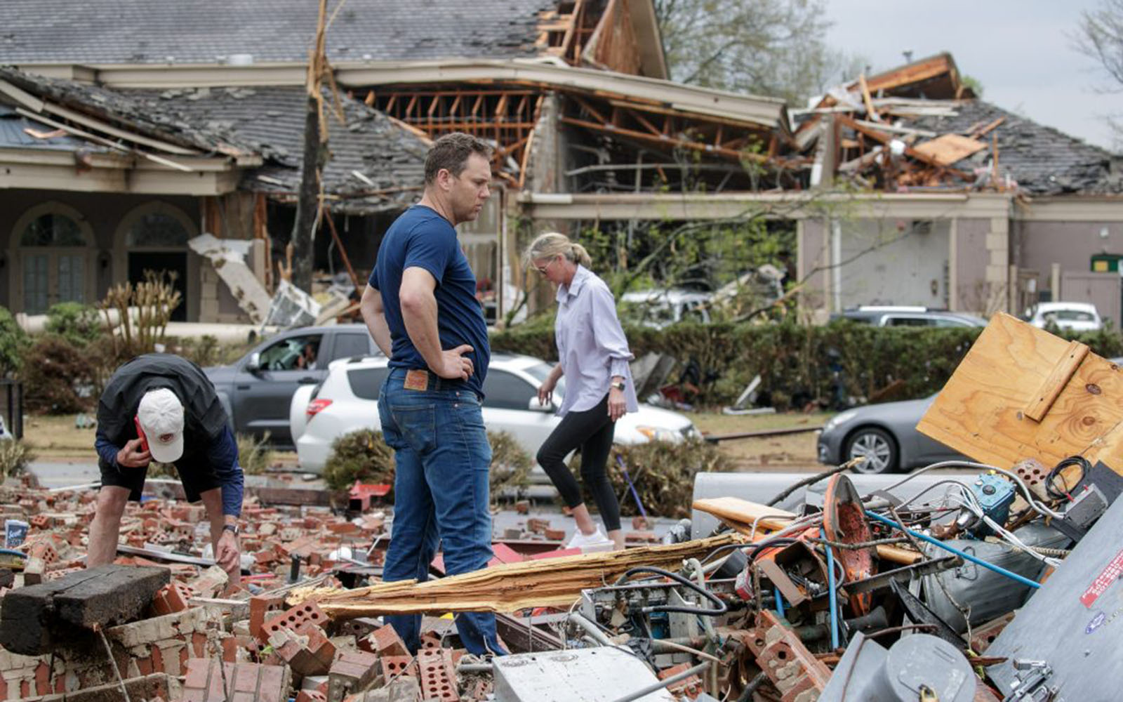 A family searches through rubble for a video recorder they think captured a direct strike to their business, Champs Car Wash, after a tornado damaged hundreds of homes and buildings on March 31, 2023 in Little Rock, Arkansas. (Photo by Benjamin Krain/Getty Images)