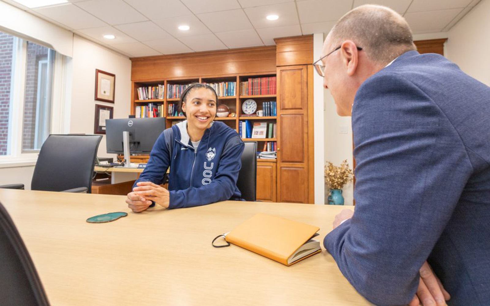 Two people sitting at a table having a discussion