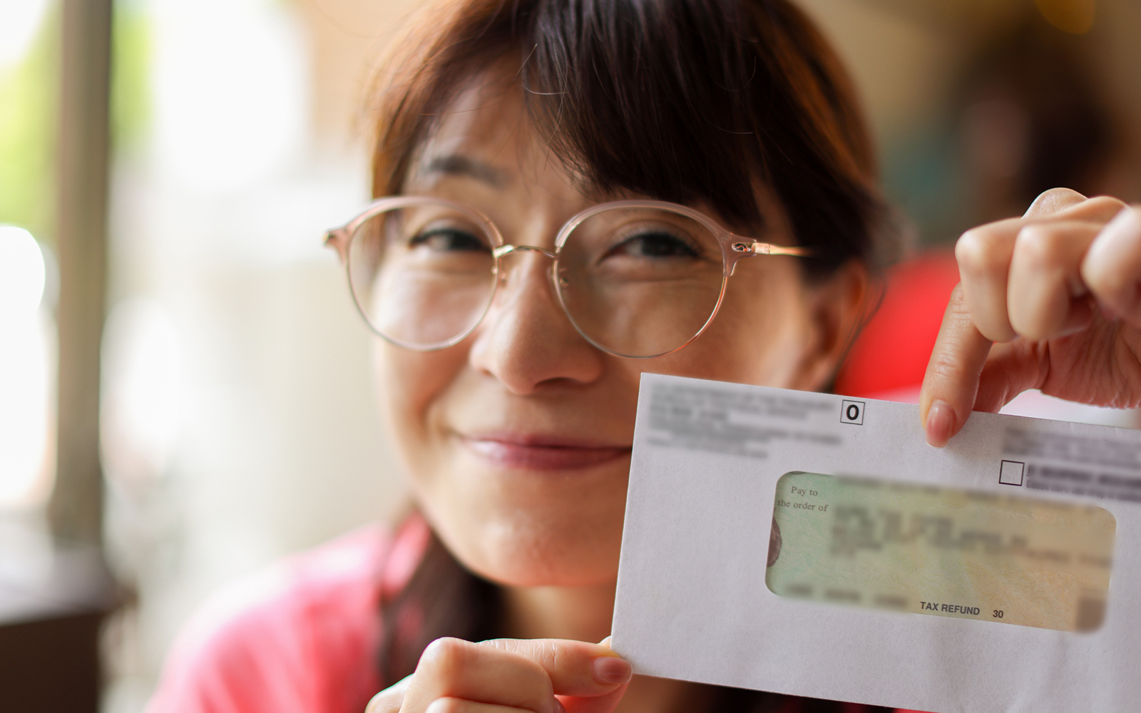 Woman happily shows off after receiving tax refund check from government in office,