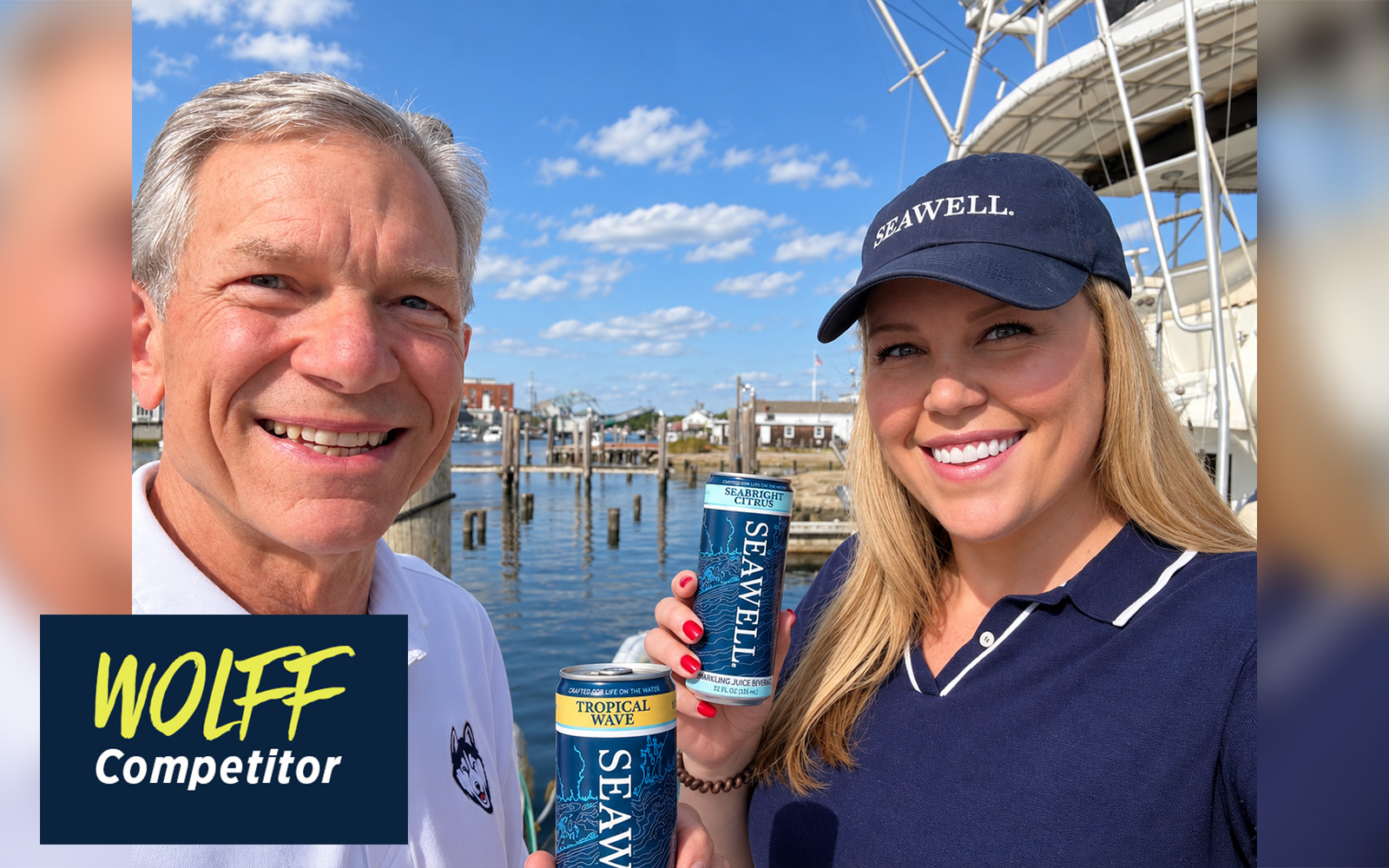 A man and woman stand in front of a dock on a sunny day, holding a SEAWELL beverage can.